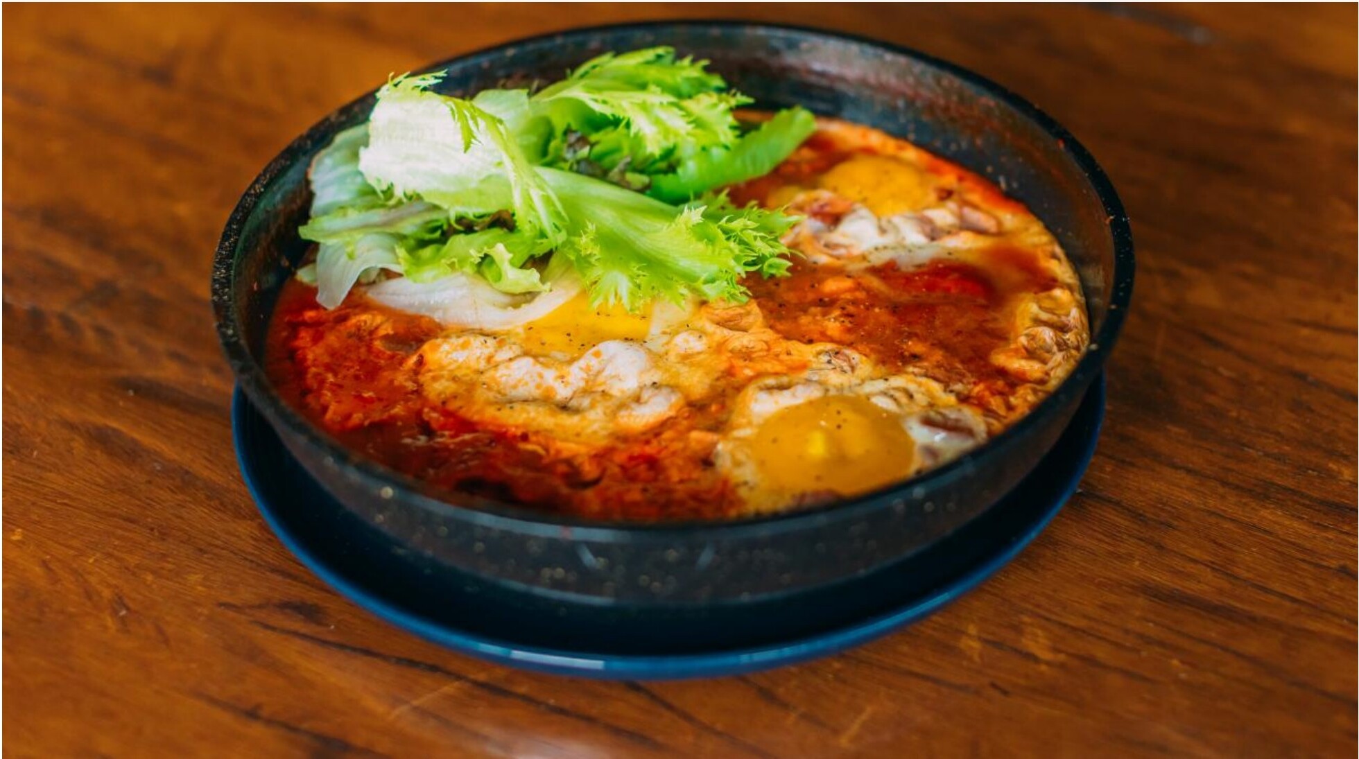 Shakshuka em panela de ferro com ovos pochados e pão